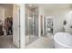 Bright bathroom featuring a glass shower, soaking tub, walk-in closet, and convenient access to the bedroom at 1195 Fox Hills Ct, Erie, CO 80516