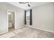 Sunlit bedroom with a window, open bathroom, and neutral carpet at 1195 Fox Hills Ct, Erie, CO 80516