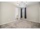 Spacious bedroom with a modern light fixture, grey carpet, and a window with black curtains at 1195 Fox Hills Ct, Erie, CO 80516