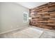 Unique bedroom featuring a striking wood accent wall, plush rug, and plenty of natural light at 1195 Fox Hills Ct, Erie, CO 80516