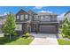 Beautiful two-story home featuring stone accents, a two-car garage, and manicured landscaping at 1195 Fox Hills Ct, Erie, CO 80516