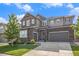 Stylish residence displaying a mix of stone and siding, a large driveway, and manicured front yard at 1195 Fox Hills Ct, Erie, CO 80516