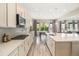 Spacious kitchen with stainless appliances, white cabinets and quartz countertop island is open to dining, living areas at 1195 Fox Hills Ct, Erie, CO 80516