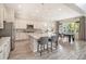 Modern kitchen with an island, bar seating, and stainless steel appliances open to the dining area at 1195 Fox Hills Ct, Erie, CO 80516