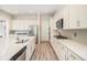 Bright kitchen features white cabinets, stainless steel appliances, and a large island with quartz countertops at 1195 Fox Hills Ct, Erie, CO 80516