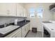 Functional laundry room equipped with sink, countertops, storage cabinets, washer, and dryer at 1195 Fox Hills Ct, Erie, CO 80516
