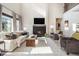 This stunning living room showcases high ceilings, lots of windows and a cozy fireplace at 1195 Fox Hills Ct, Erie, CO 80516