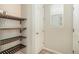 Walk-in pantry featuring wooden shelves for storage, adjacent to a door and a window at 1195 Fox Hills Ct, Erie, CO 80516