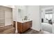 Modern bathroom features a sleek vanity, mirror, and convenient closet space at 2339 W 66Th Ave, Denver, CO 80221