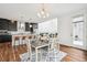 Open-concept space with a dining table, seating for four, and modern kitchen in the background at 2339 W 66Th Ave, Denver, CO 80221