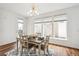 Dining area with wood floors, natural light, and seating for four with a modern light fixture at 2339 W 66Th Ave, Denver, CO 80221
