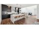 Open kitchen featuring a large island with seating, modern pendant lighting, and stylish black cabinetry at 2339 W 66Th Ave, Denver, CO 80221