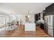Bright, open kitchen features an island, sleek black cabinets, stainless steel appliances, and wood floors at 2339 W 66Th Ave, Denver, CO 80221