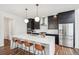 Contemporary kitchen with an oversized island, pendant lights, stainless steel appliances, and black cabinets at 2339 W 66Th Ave, Denver, CO 80221