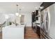Bright kitchen featuring a large island with seating, modern stainless steel appliances, and hardwood flooring at 2339 W 66Th Ave, Denver, CO 80221