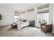 Bright bedroom featuring large windows, plush carpet, and a comfortable sitting area at 2339 W 66Th Ave, Denver, CO 80221