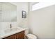 Modern powder room with white countertops, wood cabinets, and stylish fixtures provides a fresh clean space at 2339 W 66Th Ave, Denver, CO 80221