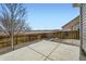 View of a concrete patio in a fenced backyard with gravel and a tree, providing a relaxing outdoor space at 4296 Clover Ln, Brighton, CO 80601