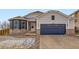 Attractive home featuring blue siding, brick accents, a large garage, and a well-kept front yard at 4296 Clover Ln, Brighton, CO 80601