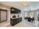 Kitchen and dining area featuring black cabinets, modern decor, and natural light at 4296 Clover Ln, Brighton, CO 80601