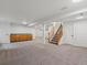 Spacious finished basement with carpeted floors, storage cabinets, and a staircase at 12695 Wolff St, Broomfield, CO 80020