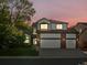 Two-story home featuring a three-car garage, white siding, and beautiful landscaping at sunset at 12695 Wolff St, Broomfield, CO 80020