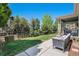 Backyard with a patio seating area, lush green lawn, and mature trees, perfect for outdoor enjoyment at 15562 E 109Th Ave, Commerce City, CO 80022