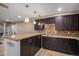 Stylish basement bar area featuring dark wood cabinets, granite countertops, and modern pendant lighting at 15562 E 109Th Ave, Commerce City, CO 80022