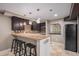 Basement bar with stone countertops, dark wood cabinets, pendant lighting, and seating for entertainment at 15562 E 109Th Ave, Commerce City, CO 80022