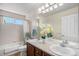 Bright bathroom with a double sink vanity and a tub/shower combination at 15562 E 109Th Ave, Commerce City, CO 80022