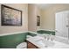 Half bathroom features modern vanity, neutral color scheme, and decorative mirror and painting at 15562 E 109Th Ave, Commerce City, CO 80022