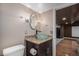 Stylish bathroom features a modern vanity with a unique glass bowl sink and contemporary lighting fixtures at 15562 E 109Th Ave, Commerce City, CO 80022