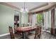 Dining room featuring a large window with natural light, elegant light fixture, and long wood table at 15562 E 109Th Ave, Commerce City, CO 80022