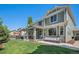 Large, fenced backyard with covered patio, dining area, swing, and lush lawn offering ample space for relaxation at 15562 E 109Th Ave, Commerce City, CO 80022