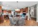 Open kitchen with stainless appliances, granite counters, wood cabinets, hardwood floors, and round dining table at 15562 E 109Th Ave, Commerce City, CO 80022
