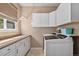 Bright laundry room features modern appliances, white cabinetry, and ample counter space at 15562 E 109Th Ave, Commerce City, CO 80022