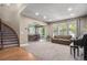 Spacious living room flowing into the dining room, featuring a large window and staircase at 15562 E 109Th Ave, Commerce City, CO 80022