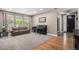 Comfortable living room features neutral tones, a large window, a piano, and hardwood floors in the entryway at 15562 E 109Th Ave, Commerce City, CO 80022