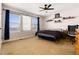 Cozy bedroom featuring three windows with scenic views, a ceiling fan, and comfortable decor at 7019 S Garrison St, Littleton, CO 80128