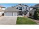 Charming two-story home featuring stone accents, a well-manicured lawn, and a spacious three-car garage at 7019 S Garrison St, Littleton, CO 80128