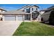 Charming two-story home featuring stone accents, a well-manicured lawn, and a spacious three-car garage at 7019 S Garrison St, Littleton, CO 80128