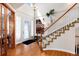 Bright foyer featuring hardwood floors, a staircase, and a decorative front door with sidelights at 7019 S Garrison St, Littleton, CO 80128