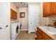 Well-lit laundry room featuring a washer, dryer, and cabinets for storage at 7019 S Garrison St, Littleton, CO 80128