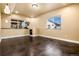 Finished basement room with stained concrete floors, two windows, and neutral colored walls at 7019 S Garrison St, Littleton, CO 80128