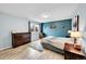 Comfortable bedroom with an accent wall, hardwood floors, and dresser at 2281 Coronado Pkwy # D, Denver, CO 80229