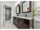 Modern bathroom with double sink vanity, mosaic tile backsplash, and a glass-enclosed shower at 2853 Yosemite St, Denver, CO 80238