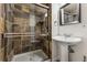 Bathroom with a pedestal sink and a glass enclosed walk-in shower with stone surround at 2853 Yosemite St, Denver, CO 80238
