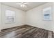 A bright bedroom featuring modern flooring, two windows, and white trim at 2853 Yosemite St, Denver, CO 80238
