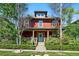 Charming red two-story home with inviting front porch and well-manicured landscaping at 2853 Yosemite St, Denver, CO 80238