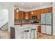 Modern kitchen features an island, stainless steel appliances, wood cabinets, and stylish backsplash at 2853 Yosemite St, Denver, CO 80238